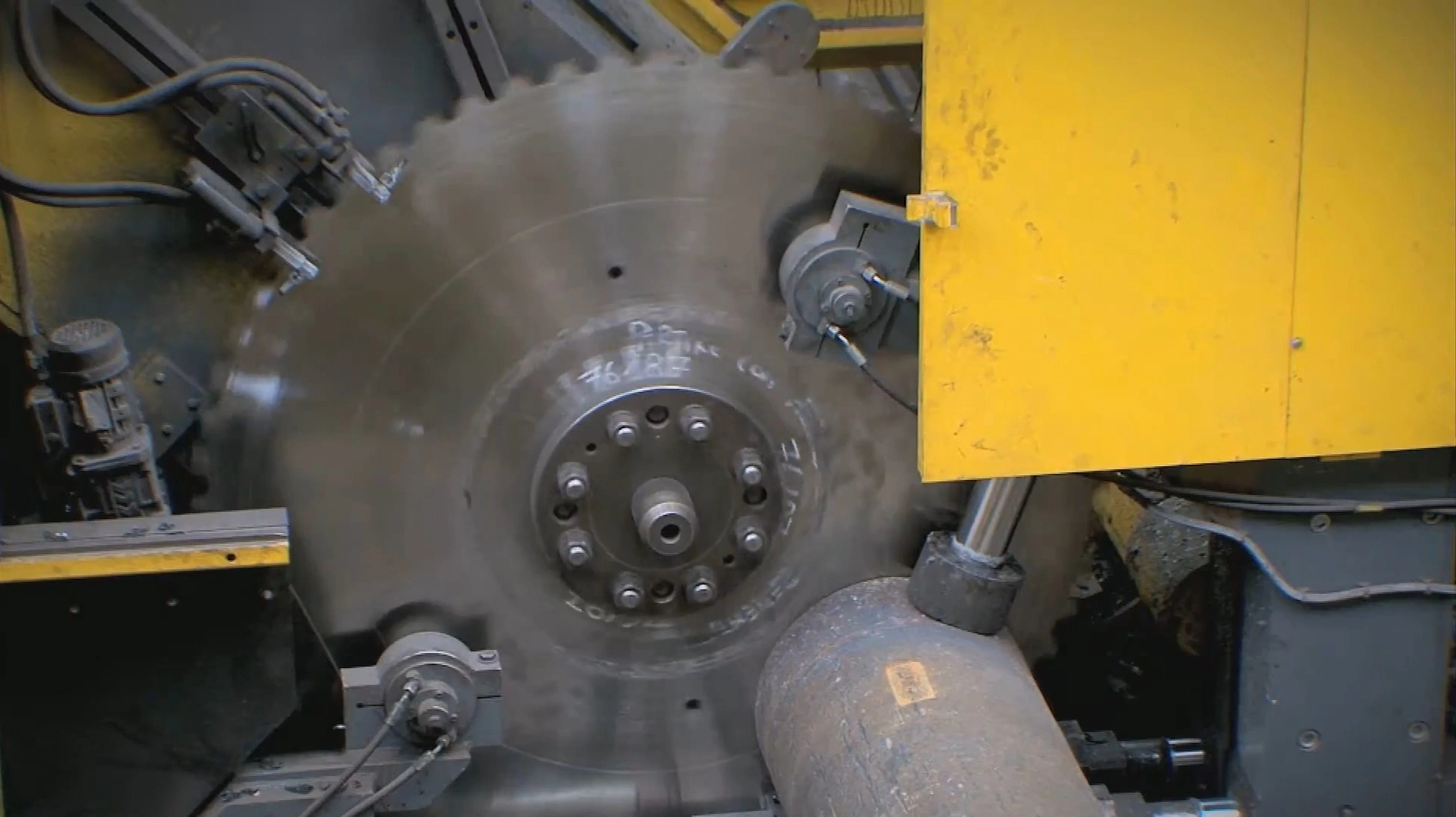 Heavy-duty circular cold saw cutting solid steel billet on a metallurgy line